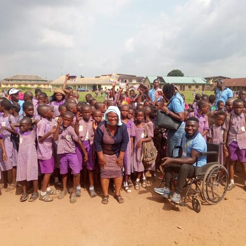 BBSI volunteers with schoolchildren, including a volunteer in a wheelchair, at a school outreach