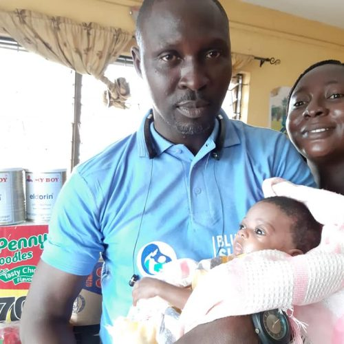 A BBSI volunteer and a mother caring for her newborn baby