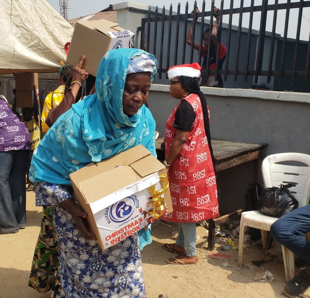 A beneficiary carrying her Christmas In A Box gift home