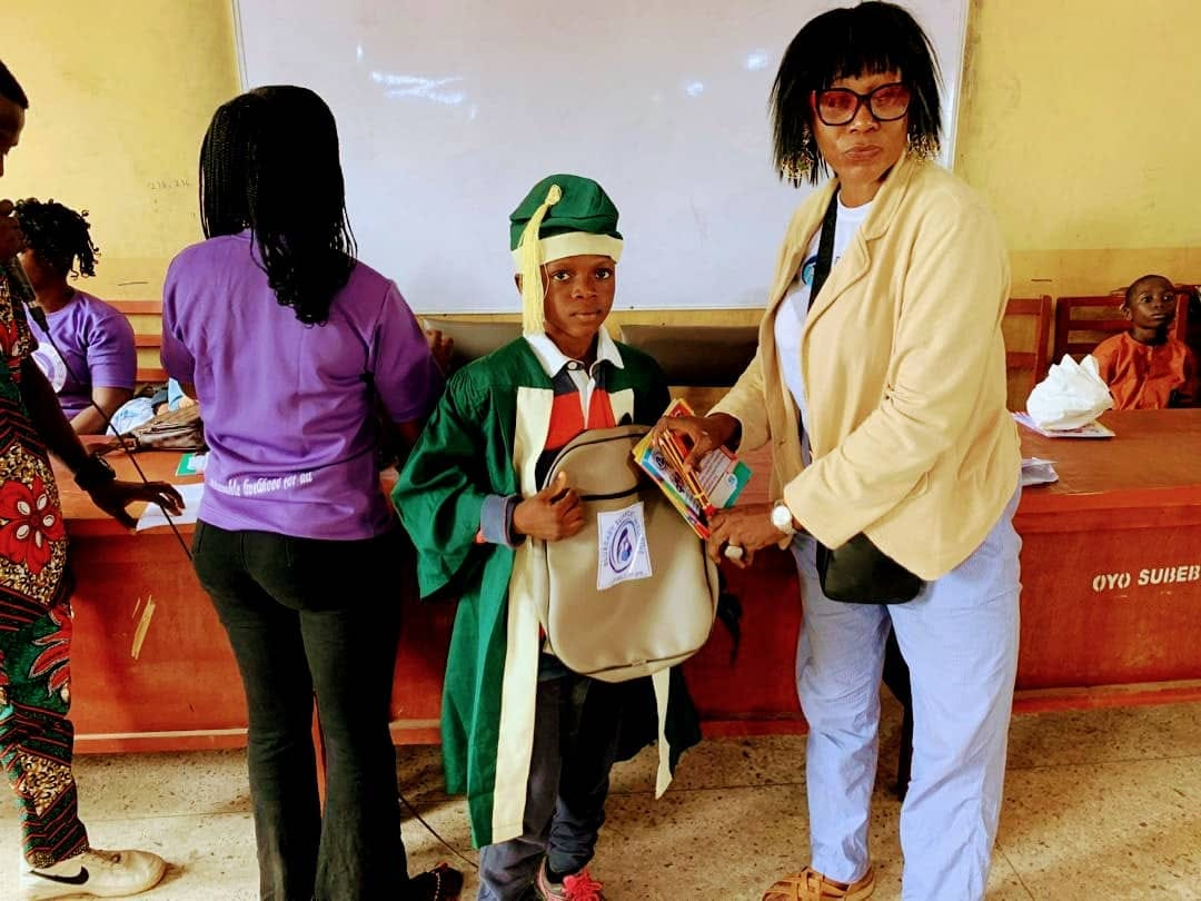 A student receiving school supplies from a BBSI volunteer